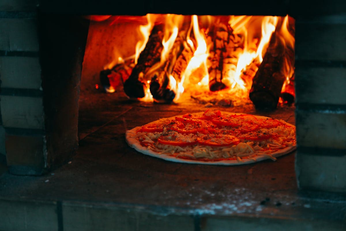Pizza recién hecha dentro del horno a leña